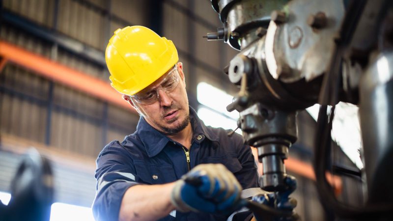 EU worker at ABflexkracht repairing a machine.